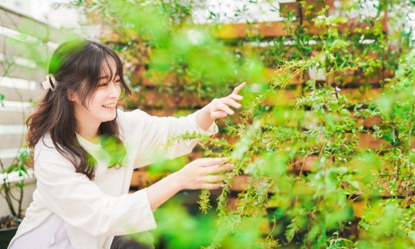 庭の植栽を見ている女性