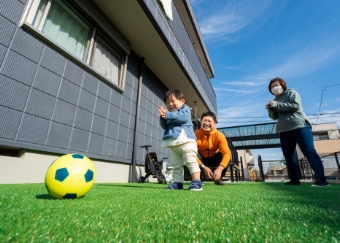 芝の上で子供がサッカーをしている様子