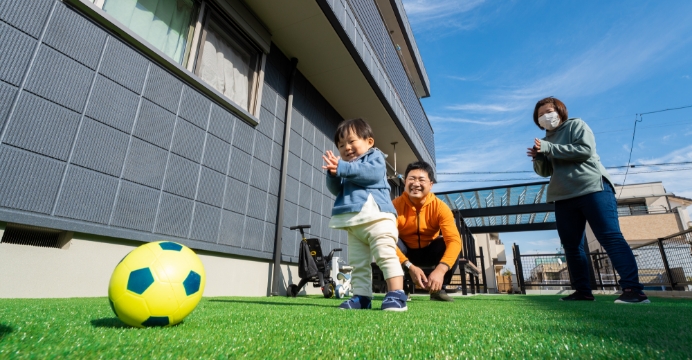 芝の上で子供がサッカーをしている様子